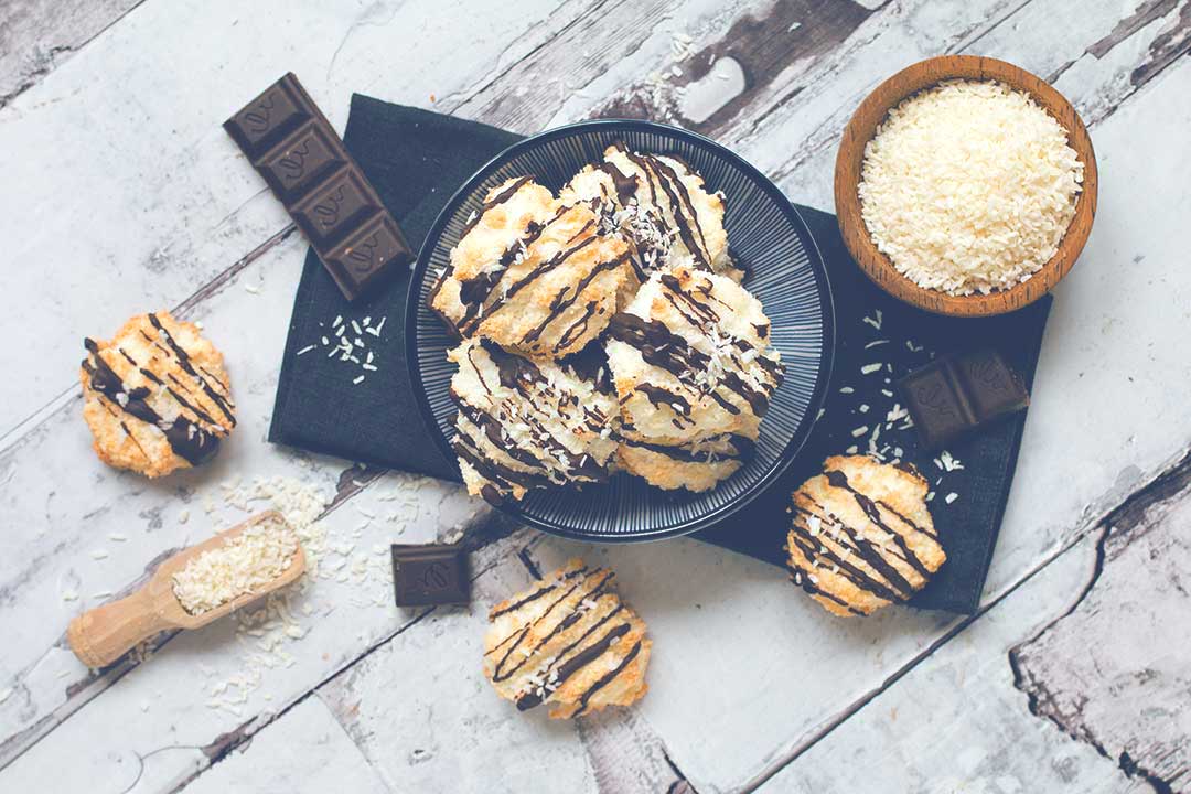 Kokosmakronen mit Seeberger Kokosraspeln und Zartbitterschokolade auf Holzplatte