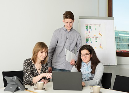 Seeberger drei Personen am Laptop mit Flipchart im Hintergrund