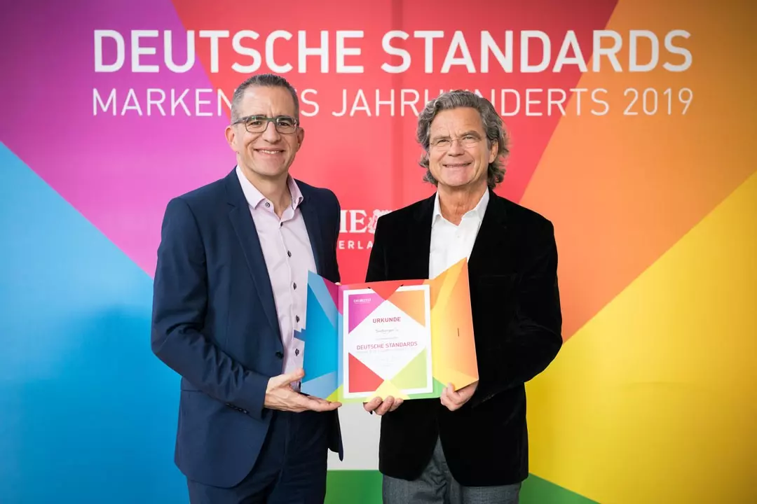 Pressesprecher Joachim Mann mit Urkunde "Marke des Jahrhunderts"