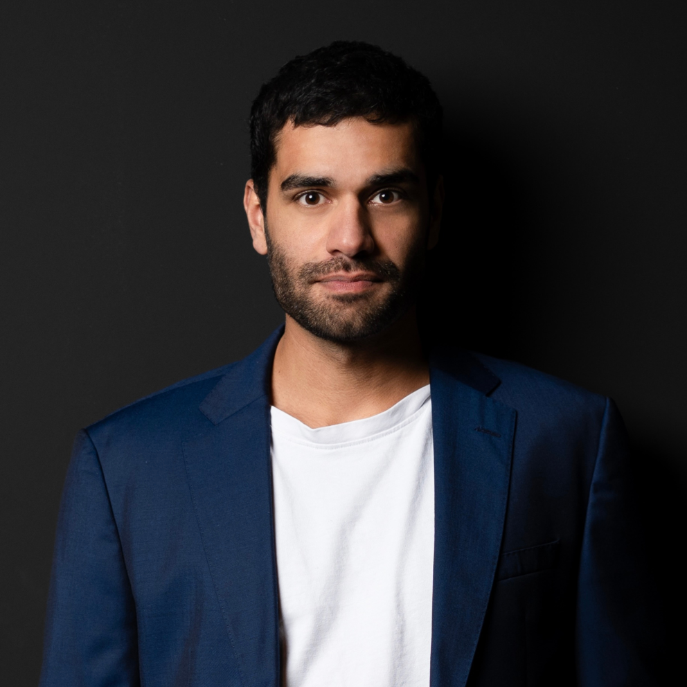 Pressekontakt_Nicolas_Galagoda_ Mann mit weißem Shirt und blauem Jackett sieht in die Kamera